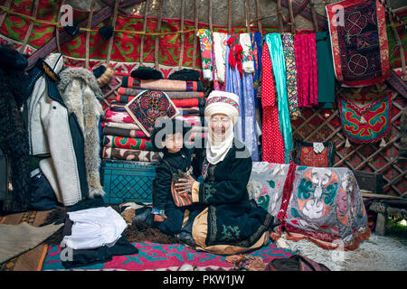 Kyrchyn, Kyrgyzstan, 6th September 2018:  Kyrgyz mother and her son in their home yurt Stock Photo