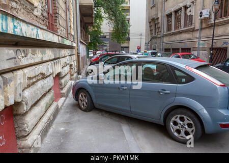 Typical pavement car parking in central Bucharest, Romania.  Parking on pavements, in driving lanes & blocking others is normal in Bucharest. Stock Photo