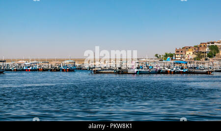Colourful river boats moored by Aswan Low Dam on Lake Nasser for tourists visiting Philae Temple, Aswan, Egypt, Africa Stock Photo