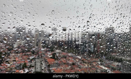 Rainwater drops on the window and on various background building unfocused. Window with rainwater drops. Stock Photo