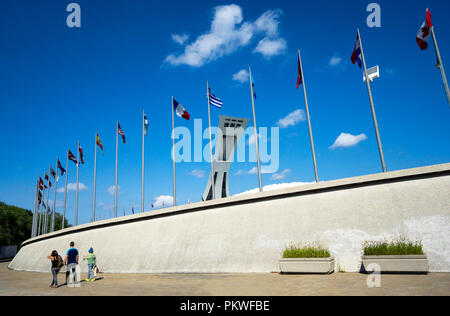 Three tourists walking near the Montreal Tower at the Montreal Olympic Stadium in QC, Canada Stock Photo