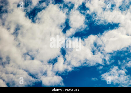 a picture of fluffy white clouds floating on a blue sky Stock Photo