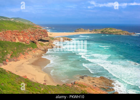 Aerial view at sunset from the cliffs of Robberg Nature Reserve, Plettenberg Bay, South Africa. Beach, waves and seal colony on the horizon. Stock Photo