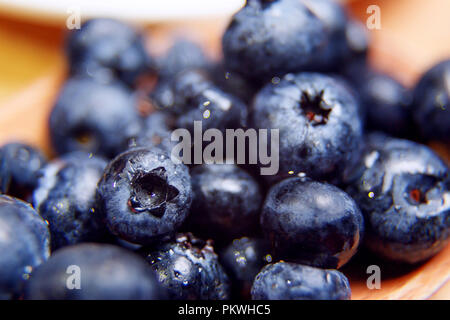 Fresh blueberry with drops of water in wooden bowl. Top view. Concept of healthy and dieting eating Stock Photo