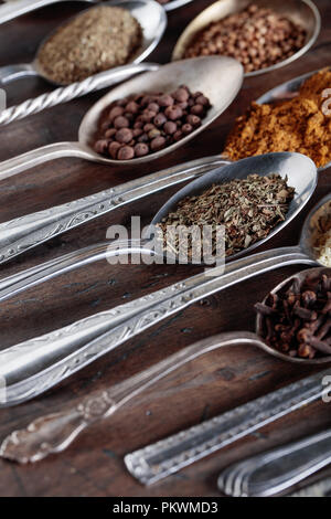 Different spices in  spoons on a old wooden background. Stock Photo