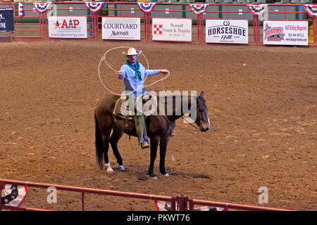 Staycation idea. Texas Cowboy on horse demonstrates spinning rope tricks at Pawnee Bill’s Wild West Rodeo Show.  Fort Worth Stockyards, Texas. Stock Photo