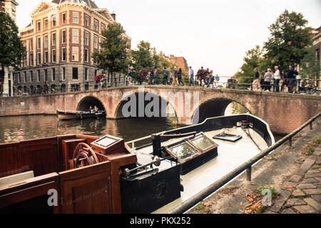 Amsterdam view of canal and bridge with vintage wooden boat Stock Photo