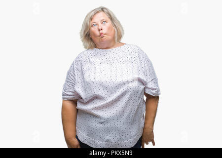 Senior plus size caucasian woman over isolated background making fish face with lips, crazy and comical gesture. Funny expression. Stock Photo