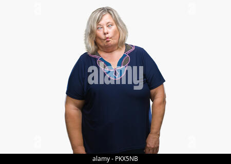 Senior plus size caucasian woman over isolated background making fish face with lips, crazy and comical gesture. Funny expression. Stock Photo