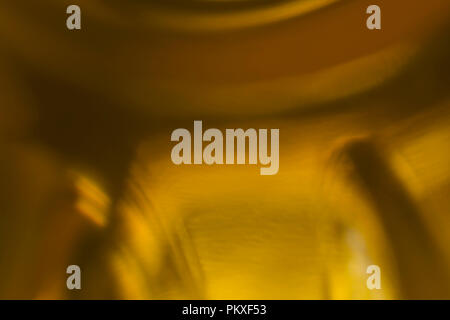 Blurred macrophotography. The bottom of the plastic bottle,  with yellow vegetable oil.Site about kitchen, photography, art,abstraction,food industry. Stock Photo