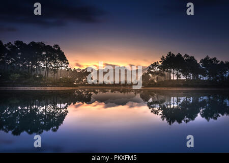 Beautiful dawn on the lake with pink clouds and reflecting sun rays at Ban Ang village, Moc Chau, Son La Province, Vietnam Stock Photo