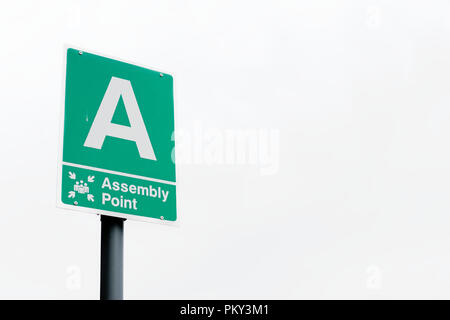 Fire assembly point sign at workplace in empty sky Stock Photo