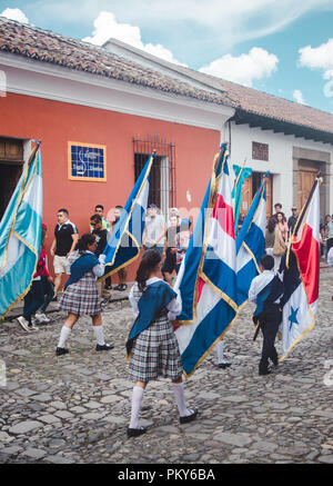 Children carry flags of Guatemala, Costa Rica, Nicaragua, El Salvador & Honduras as part of a marching parade for Dia de la Independencia in Antigua Stock Photo