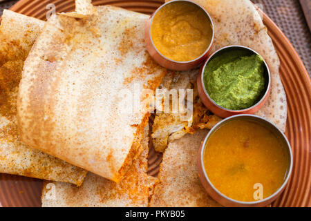 Close-up of Masala Dosa with chutneys served in a small bowls Stock Photo