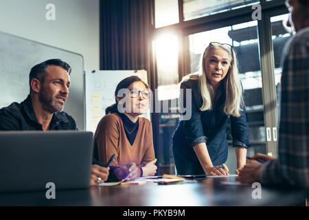 Business people paying attention to colleagues discussion in conference room. Business team brainstorming in conference room. Stock Photo