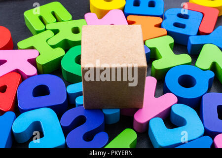 Cardboard box cube and Colorful Letters of Alphabet Stock Photo