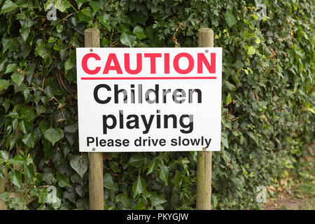 Caution children playing please drive slowly road sign close up, Sutton, Suffolk, England, UK Stock Photo