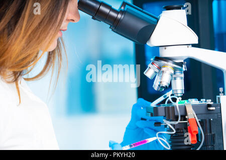 technician girl with microfluidic device LOC in microbiological lab Stock Photo