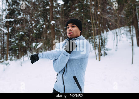 Man doing stretching exercise in a park Stock Photo