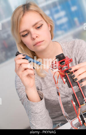 Young attractive female engineer working on robotics project Stock Photo