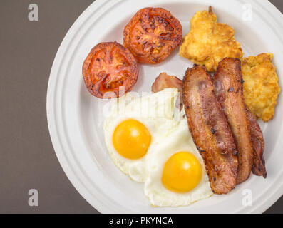 Bacon and egg breakfast with hash browns and fried tomato - Top view photo Stock Photo