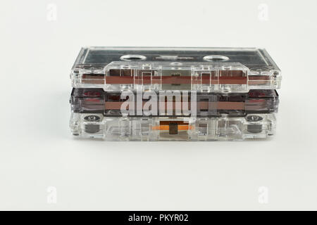 Stack of vintage audio cassettes. Three transparent audio cassettes on white background. Compact music storage in vintage style. Stock Photo