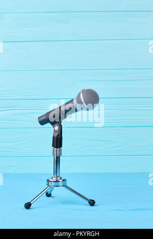Microphone on blue wooden background. Stock Photo