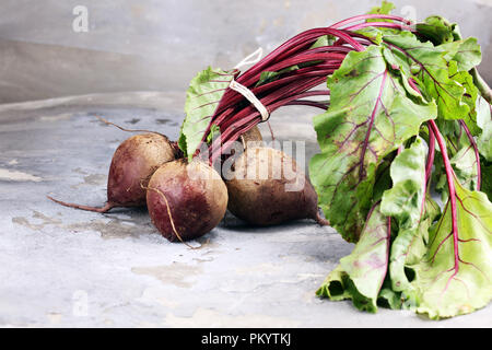Red Beetroot with herbage green leaves on rustic background. Organic Beetroot. Stock Photo