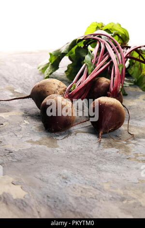 Red Beetroot with herbage green leaves on rustic background. Organic Beetroot. Stock Photo