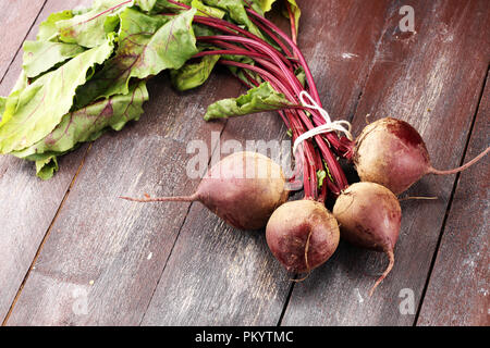 Red Beetroot with herbage green leaves on rustic background. Organic Beetroot. Stock Photo