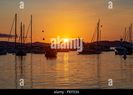 Ferry Boat passing in front of setting sun on Lake Champlain. Stock Photo