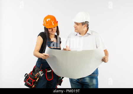 Portrait Of Male Architect And builder Woman Discussing building plan. foreman holding roll paper Stock Photo