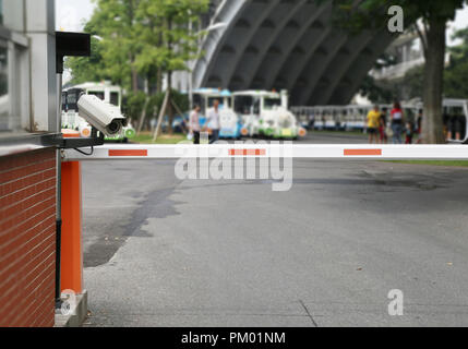 Parking lot barrier gate with security surveillance camera at entrance Stock Photo