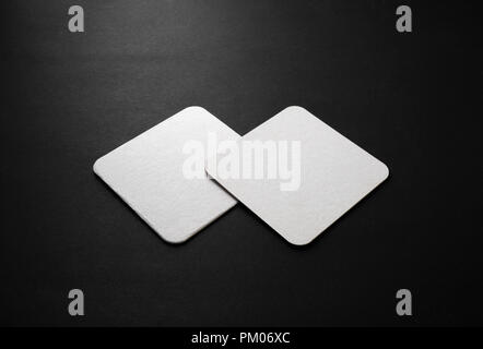 Blank square beer coasters mockup on black background. Stock Photo