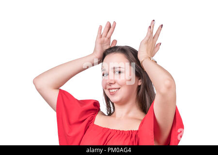 Woman in red dress holds an imaginary crown on her head, isolated on white background Stock Photo