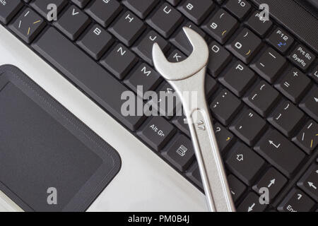 Spanner on the laptop keyboard, the concept of repairing machinery Stock Photo