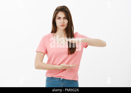 A girl with a big chest in her underwear is standing near a table