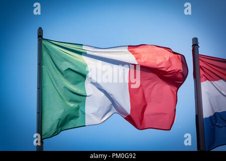 Italian flag fluttering in the wind, with blue sky. Stock Photo
