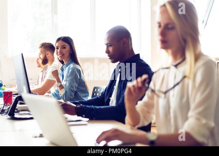 Confident and successful. Young modern colleagues in smart casual wear working while spending time in the office. Stock Photo