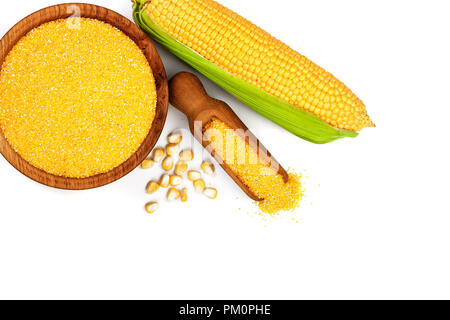 corn groats or cornmeal in wooden bowl and corncob isolated on white background. Top view. Flat lay Stock Photo