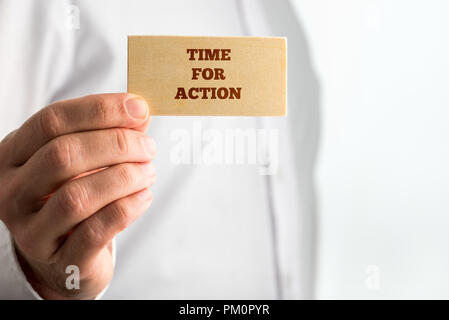 Businessman Showing Small Wooden Piece with Time for Action Texts on White Background. A Creative Concept for Action Concept. Stock Photo