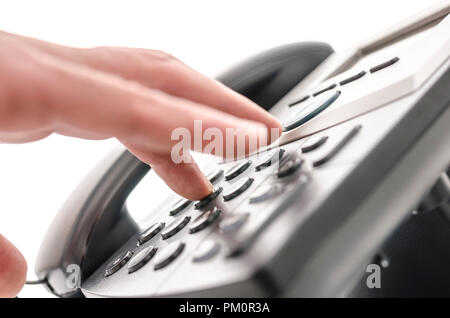 Detail of a hand pressing a button on a telephone keypad. With selective focus. Stock Photo