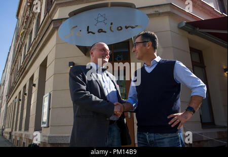 Chemnitz, Saxony. 16th Sep, 2018. Cem Ozdemir (R), member of the Bundestag for Alliance 90/The Greens, talking to Uwe Dziuballa in front of his Jewish restaurant 'Schalom' in Chemnitz. After an anti-Semitic attack on the restaurant at the end of August, Ozdemir arranged a solidarity dinner with the host against anti-Semitism. Credit: Hendrik Schmidt/dpa-Zentralbild/dpa/Alamy Live News Stock Photo