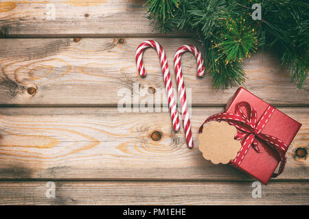Christmas gift box with blank tag and ornaments on wooden background, copy space, top view Stock Photo