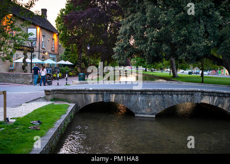 Bourton-on-the-Water in the Cotswolds District of England low stone footbridges over the River Windrush. Stock Photo