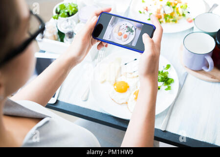Woman Taking Photo of Food  in Cafe Stock Photo