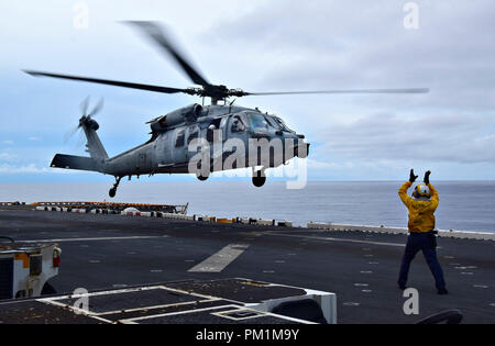 180914-N-RI884-0346  PACIFIC OCEAN (Sept. 14, 2018) - Aviation Boatswain's Mate (Aircraft Handling) 3rd Class Noel Rulloda from Chicago, Illinois, directs an MH-60S Sea Hawk helicopter, assigned to the “Island Knights” of Helicopter Sea Combat Squadron (HSC) 25 during takeoff from the amphibious assault ship USS Wasp (LHD 1). Wasp, flagship of the Wasp Expeditionary Strike Group, with embarked 31st Marine Expeditionary Unit, is operating in the Indo-Pacific region to enhance interoperability with partners and serve as a ready-response force for any type of contingency. (U.S. Navy photo by Mass Stock Photo
