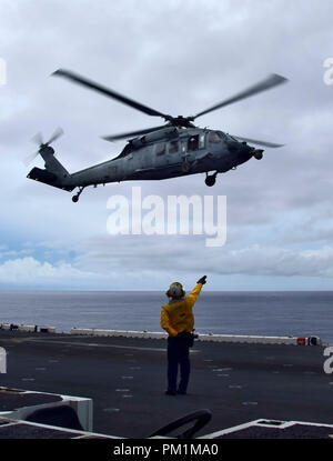 180914-N-RI884-0361  PACIFIC OCEAN (Sept. 14, 2018) - Aviation Boatswain's Mate (Aircraft Handling) 3rd Class Noel Rulloda from Chicago, Illinois, directs an MH-60S Sea Hawk helicopter, assigned to the “Island Knights” of Helicopter Sea Combat Squadron (HSC) 25 during takeoff from the amphibious assault ship USS Wasp (LHD 1). Wasp, flagship of the Wasp Expeditionary Strike Group, with embarked 31st Marine Expeditionary Unit, is operating in the Indo-Pacific region to enhance interoperability with partners and serve as a ready-response force for any type of contingency. (U.S. Navy photo by Mass Stock Photo