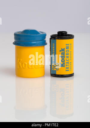 A 20 exposure roll of Kodak Ektachrome slide film and its yellow metal canister with it color coded blue screw top lid Stock Photo