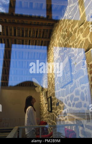 (180917) -- PINGTAN, Sept. 17, 2018 (Xinhua) -- Lin I Chen, a Taiwanese, views the stone-themed picture at the 'Rocks Can Sing' art zone in Beigang Village of Pingtan County, southeast China's Fujian Province, Sept. 6, 2018. When tourists get close to 'Rocks Can Sing,' they may see artists playing music with the rocks, and people sipping coffee in rock houses. 'Rocks Can Sing' is an art project which takes in accommodation, live music, restaurant, cafe and souvenir store. Now, a total of 10 young people from the mainland and Taiwan, including Taiwanese Lin I Chen and her boyfriend Stock Photo